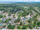 Expansive aerial showcases homes with tree coverage and lake views in a residential neighborhood at 10739 Lake Ralph Dr, Clermont, FL 34711
