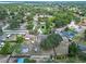 Expansive aerial view of a home featuring a pool, garden, and enclosed patio within a lush, tree-filled neighborhood at 10739 Lake Ralph Dr, Clermont, FL 34711