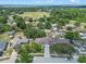 Expansive aerial view of neighborhood homes with lush trees, green field and tranquil lake at 10739 Lake Ralph Dr, Clermont, FL 34711