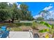 Spacious backyard with healthy trees, a shed, a garden bed, and patio seating for entertaining at 10739 Lake Ralph Dr, Clermont, FL 34711