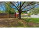 Backyard featuring mature shade trees, a storage shed, and a swing set at 10739 Lake Ralph Dr, Clermont, FL 34711