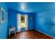 Bright blue bedroom featuring parquet floors, natural light from the window, and stylish decor at 10739 Lake Ralph Dr, Clermont, FL 34711