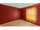 Cozy bedroom with rust-colored walls, beige tile, and a sun-drenched yellow curtain at 10739 Lake Ralph Dr, Clermont, FL 34711
