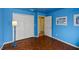 Bright blue bedroom featuring a wood-look floor, closet and adjoining doorway to an adjacent room at 10739 Lake Ralph Dr, Clermont, FL 34711
