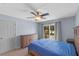 Bright bedroom featuring a wooden bed frame, dresser, and a sliding glass door to the backyard at 10739 Lake Ralph Dr, Clermont, FL 34711