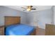 Light and airy bedroom with a wooden bed, neutral walls, and tile flooring, creating a relaxing atmosphere at 10739 Lake Ralph Dr, Clermont, FL 34711