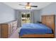 Bright bedroom featuring a wooden bed frame, dresser, and a sliding glass door to the backyard at 10739 Lake Ralph Dr, Clermont, FL 34711
