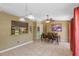 Open dining and living area featuring tile flooring, a decorative lighting fixture, and view of the kitchen bar at 10739 Lake Ralph Dr, Clermont, FL 34711