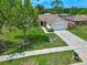 Aerial view of a single-Gathering home featuring a well-manicured lawn, driveway, and attached garage at 10739 Lake Ralph Dr, Clermont, FL 34711