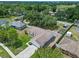 Aerial shot of a charming single Gathering home featuring a driveway and a well-maintained yard with a garden at 10739 Lake Ralph Dr, Clermont, FL 34711