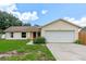 Inviting single-story home with a well-manicured lawn, attached two-car garage, and a striking red front door at 10739 Lake Ralph Dr, Clermont, FL 34711
