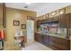 Stylish kitchen featuring rich wood cabinetry, granite counters, tile flooring and built in wine storage at 10739 Lake Ralph Dr, Clermont, FL 34711
