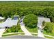 An aerial view featuring a home with solar panels, a private pool, a large tree and an oversized driveway at 10743 Fairhaven Way, Orlando, FL 32825