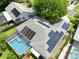 Aerial view showcasing solar panels, screened-in pool, and lush backyard of this well-maintained home at 10743 Fairhaven Way, Orlando, FL 32825
