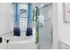 Bathroom showcasing a garden tub with blue castle curtains and a glass door shower at 10743 Fairhaven Way, Orlando, FL 32825