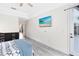 Bright bedroom features gray wood floors and a beach scene on the wall-mounted TV at 10743 Fairhaven Way, Orlando, FL 32825