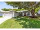 Charming single-story home with a well-manicured lawn, beautiful red door, and mature landscaping at 10743 Fairhaven Way, Orlando, FL 32825