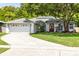 Charming single-story home with a well-manicured lawn, mature trees, and a driveway leading to a two-car garage at 10743 Fairhaven Way, Orlando, FL 32825