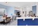 Well-lit kitchen with blue cabinetry, a breakfast bar, and dining area featuring unique wood and metal chairs at 10743 Fairhaven Way, Orlando, FL 32825