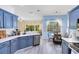 Modern kitchen with stainless steel appliances, white countertops, blue cabinets, and an adjacent dining area at 10743 Fairhaven Way, Orlando, FL 32825