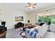 Comfortable living area with hardwood flooring, a ceiling fan, and a large window offering natural light and views at 10743 Fairhaven Way, Orlando, FL 32825