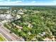 An aerial view showcases homes nestled among mature trees near commercial areas and roadways at 109 Crown Oaks Way # 109, Longwood, FL 32779
