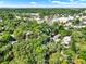 Aerial view shows properties surrounded by mature trees near a road and a parking area at 109 Crown Oaks Way # 109, Longwood, FL 32779