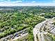Aerial view shows multi-Gathering homes surrounded by nature, alongside commercial buildings and a busy roadway at 109 Crown Oaks Way # 109, Longwood, FL 32779