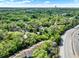 An aerial view presents homes nestled among verdant trees alongside a highway, offering a scenic landscape at 109 Crown Oaks Way # 109, Longwood, FL 32779