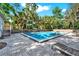 Community pool with surrounding brick pavers, lounge chairs, and mature landscaping at 109 Crown Oaks Way # 109, Longwood, FL 32779