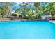 Large community pool surrounded by lush landscaping and mature trees at 109 Crown Oaks Way # 109, Longwood, FL 32779