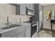 Kitchen features stainless steel appliances, gray cabinets and quartz countertops at 109 Crown Oaks Way # 109, Longwood, FL 32779