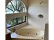 Bright bathroom featuring a large soaking tub with jets and scenic window views at 1252 Lake Willisara Cir # Ge, Orlando, FL 32806