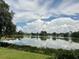 Scenic lake view with lush greenery and a clear blue sky with fluffy white clouds at 1252 Lake Willisara Cir # Ge, Orlando, FL 32806