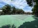 Well-maintained community tennis court with green surface, surrounded by trees and community buildings at 1252 Lake Willisara Cir # Ge, Orlando, FL 32806