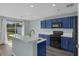 Eat-in kitchen features black appliances, blue cabinets and granite countertops, with a backyard view at 126 San Carlo Rd, Davenport, FL 33896