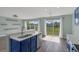 Sunlit eat-in kitchen with blue cabinets and bar seating overlooking the backyard at 126 San Carlo Rd, Davenport, FL 33896