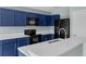 Close up shot of kitchen featuring blue cabinets, quartz countertops, and stainless steel appliances at 126 San Carlo Rd, Davenport, FL 33896