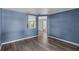 Open-concept living room with blue walls and modern gray wood-look flooring at 126 San Carlo Rd, Davenport, FL 33896