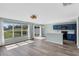 Bright living room with sliding glass doors, hardwood-style floors and adjacent modern kitchen at 126 San Carlo Rd, Davenport, FL 33896
