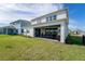 Rear view of home's patio, including outdoor dining set and landscaped backyard at 13323 Panama Beach Ct, Orlando, FL 32827
