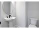 A half bathroom featuring a pedestal sink and commode at 13323 Panama Beach Ct, Orlando, FL 32827
