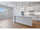 Kitchen features white cabinetry, modern light fixtures, stainless steel appliances, and a center island at 13323 Panama Beach Ct, Orlando, FL 32827