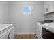 Well-lit laundry area featuring white cabinetry and modern washer and dryer at 13323 Panama Beach Ct, Orlando, FL 32827