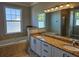 Spacious bathroom featuring double sink vanity, bathtub, and large window, providing an inviting and functional space at 1414 Stickley Ave, Kissimmee, FL 34747