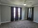 Bright bedroom with neutral walls, carpet flooring, large windows with curtains, and ceiling fan at 1414 Stickley Ave, Kissimmee, FL 34747