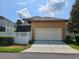 Exterior view of the garage with white door and screen patio, complemented by a green lawn and white fence at 1414 Stickley Ave, Kissimmee, FL 34747