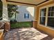 Covered front porch showcasing brick flooring and accents with classic column architecture at 1414 Stickley Ave, Kissimmee, FL 34747