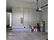 Garage featuring water heater, electrical panel, work light, with white walls, and a concrete floor at 1414 Stickley Ave, Kissimmee, FL 34747