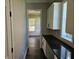 Hallway features dark countertops, white cabinets, and wood floors, leading into the living room at 1414 Stickley Ave, Kissimmee, FL 34747